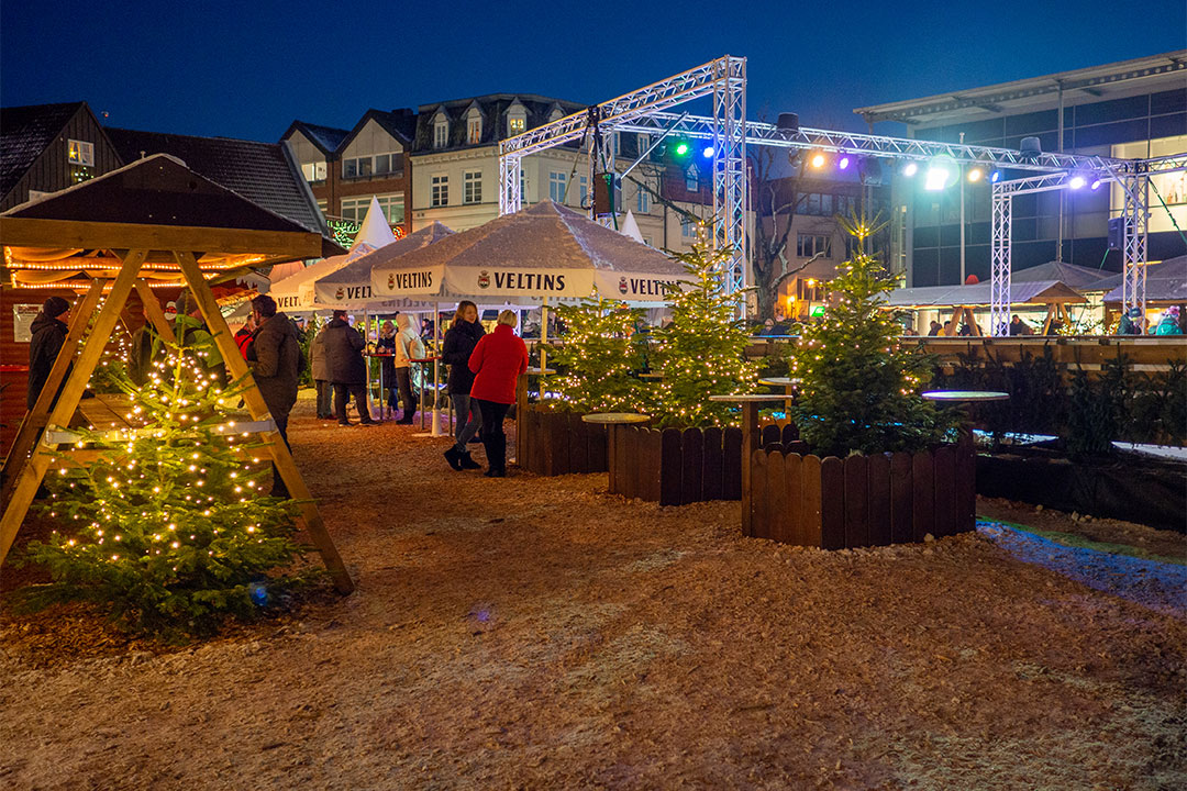 Blick auf den Rendsburger Weihnachtsmarkt mit Tannenbäumen und der Eisbahn